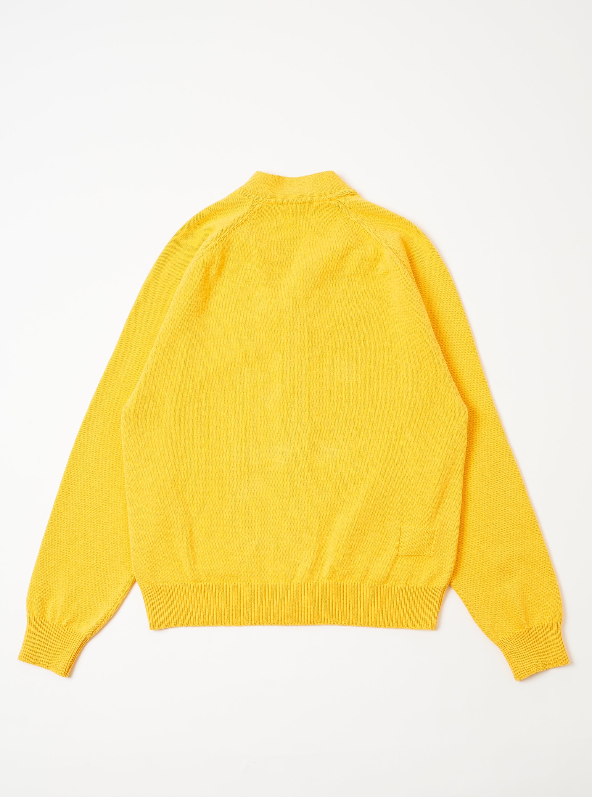 The Yellow Eco Cotton Knit Pocket David Cardigan is shown from the back as a flat lay against a plain white background. The image highlights the textured yellow knit fabric, a simple straight hem, and clean-finished seams at the shoulders and sleeves.