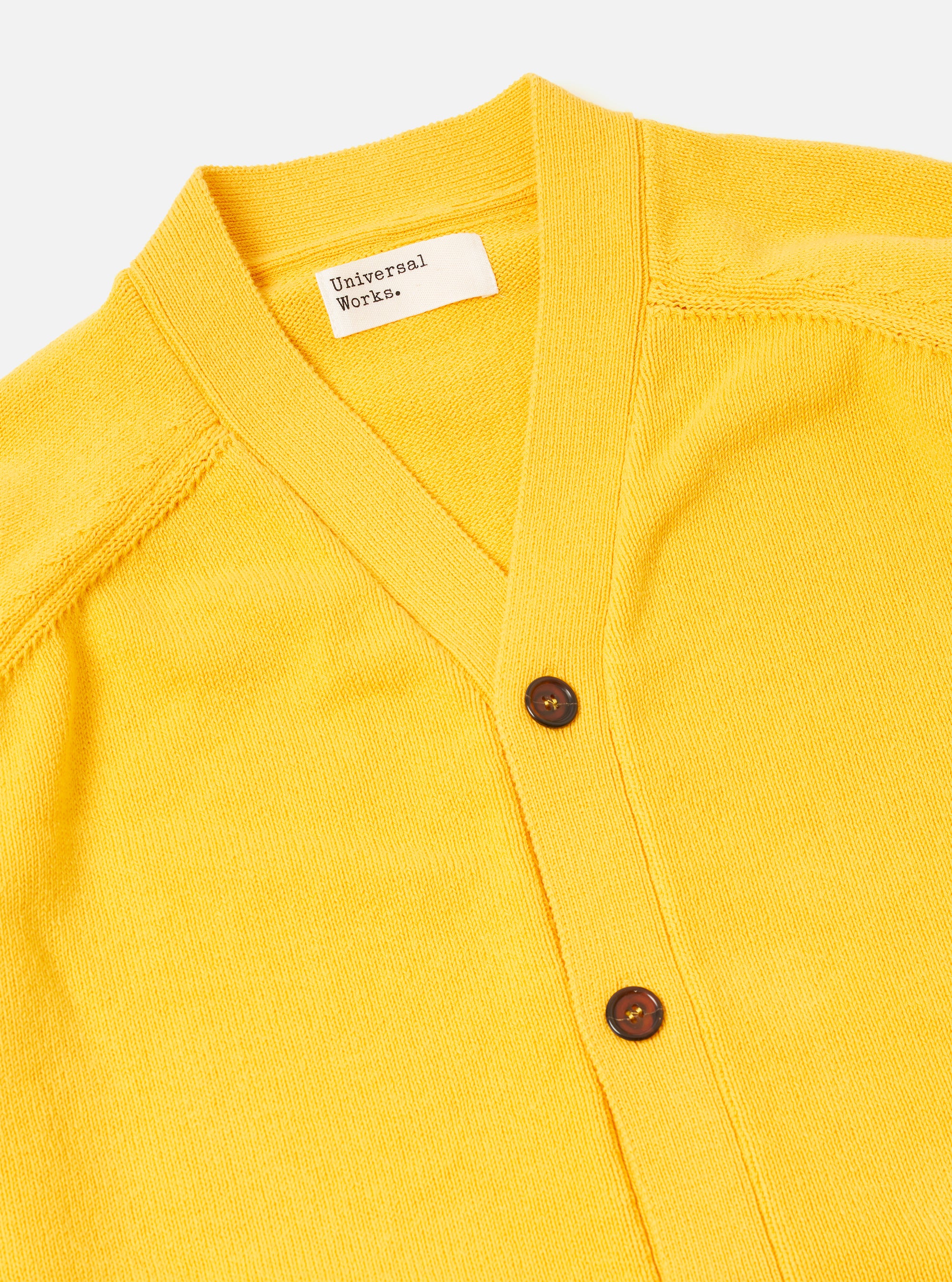 The Yellow Eco Cotton Knit Pocket David Cardigan is shown from the back as a flat lay against a plain white background. The image highlights the textured knit of the yellow recycled cotton fabric and the simple, straight-cut construction of the garment's rear.