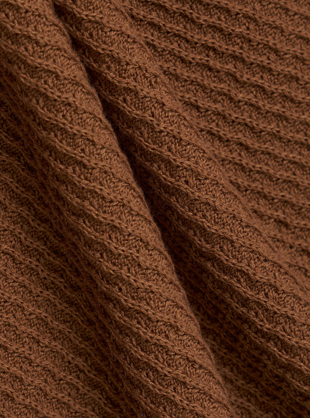 A close-up fabric swatch of the Brown Fine Texture Tricot S/S Knit Polo highlights the intricate raised rib pattern and soft texture of the brown cotton knit material. The fabric fills the frame, providing a detailed view of the garment's color and technical construction.