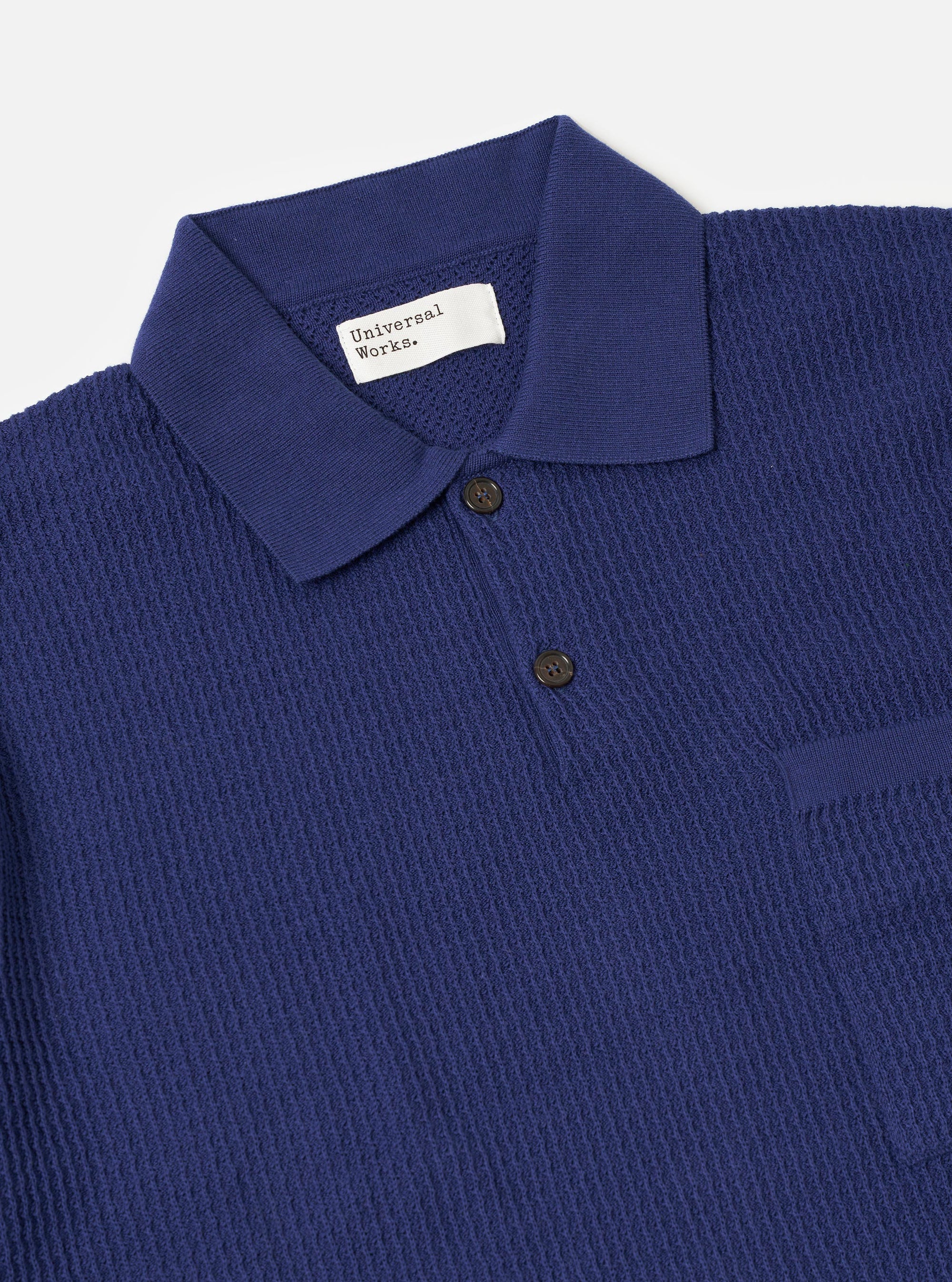 The Navy Fine Texture Tricot S/S Knit Polo is shown from the back as a flat lay against a plain white background. The image highlights the fine-textured knit fabric, the ribbed hem, and the short sleeves.
