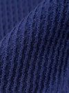 A close-up fabric swatch of the Navy Fine Texture Tricot S/S Knit Polo highlights the intricate raised rib pattern and fine tricot texture of the 100% cotton material. The image focuses on the deep navy blue color and the tactile quality of the knit.