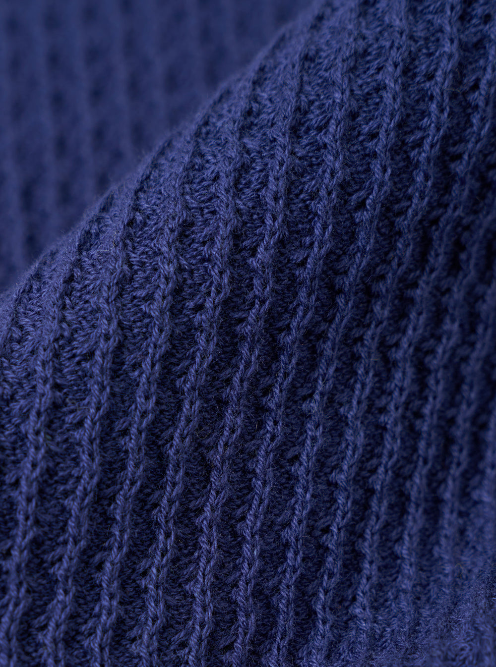 A close-up fabric swatch of the Navy Fine Texture Tricot S/S Knit Polo highlights the intricate raised rib pattern and fine tricot texture of the 100% cotton material. The image focuses on the deep navy blue color and the tactile quality of the knit.