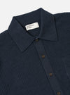 A model wears the Navy Eco Cotton Knit Jacket against a plain, light-grey background. The jacket features a five-button front closure, a structured collar, and two large patch pockets at the waist. The recycled cotton fabric has a visible, fine-gauge knitted texture.