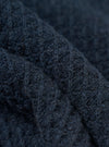 A close-up fabric swatch of the Navy Eco Cotton Knit Jacket shows the detailed texture of the dark blue knit material. The image focuses on the intricate weave and pattern of the recycled cotton threads. No model or mannequin is present.