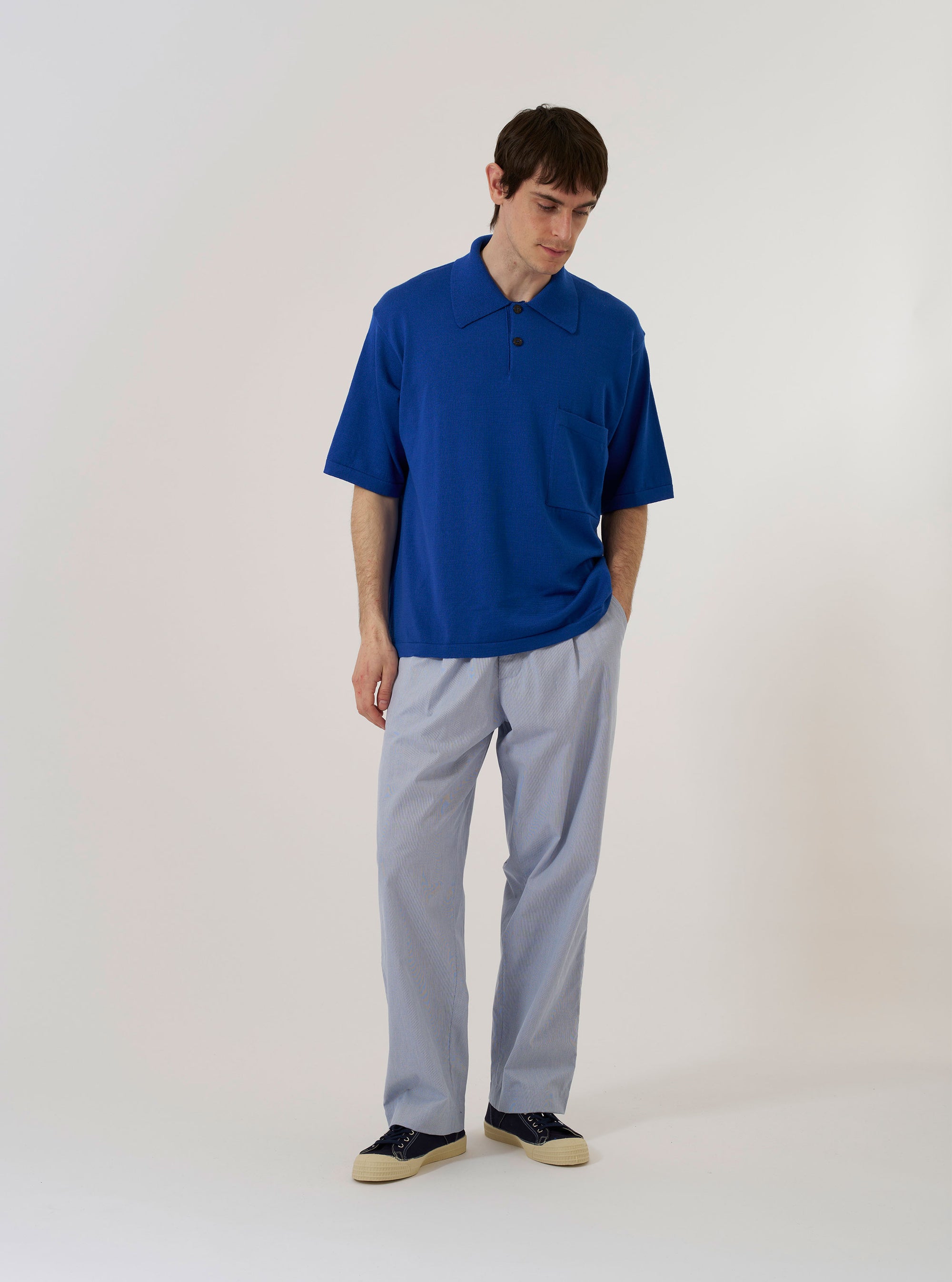 The Blue Woolcot Bio S/S Pullover Knit Shirt II is shown as a flat lay against a white background. The shirt features short sleeves, a classic pointed collar, and a three-button pullover placket. The garment is constructed from a solid blue knit fabric with a fine texture.