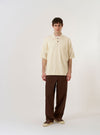 The Ecru Woolcot Bio S/S Pullover Knit Shirt II is shown as a flat lay against a plain white background. The shirt features short sleeves, a button placket with a large one-piece collar, and a single chest pocket on the left side. The ecru-colored fabric has a smooth, lightweight knit texture.