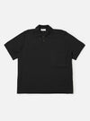 The Black Woolcot Bio S/S Pullover Knit Shirt II is shown as a flat lay against a plain white background. The shirt features a boxy fit, short sleeves, a large collar, and a button placket. A single patch pocket is positioned on the chest. The black fabric has a smooth, fine-knit texture.