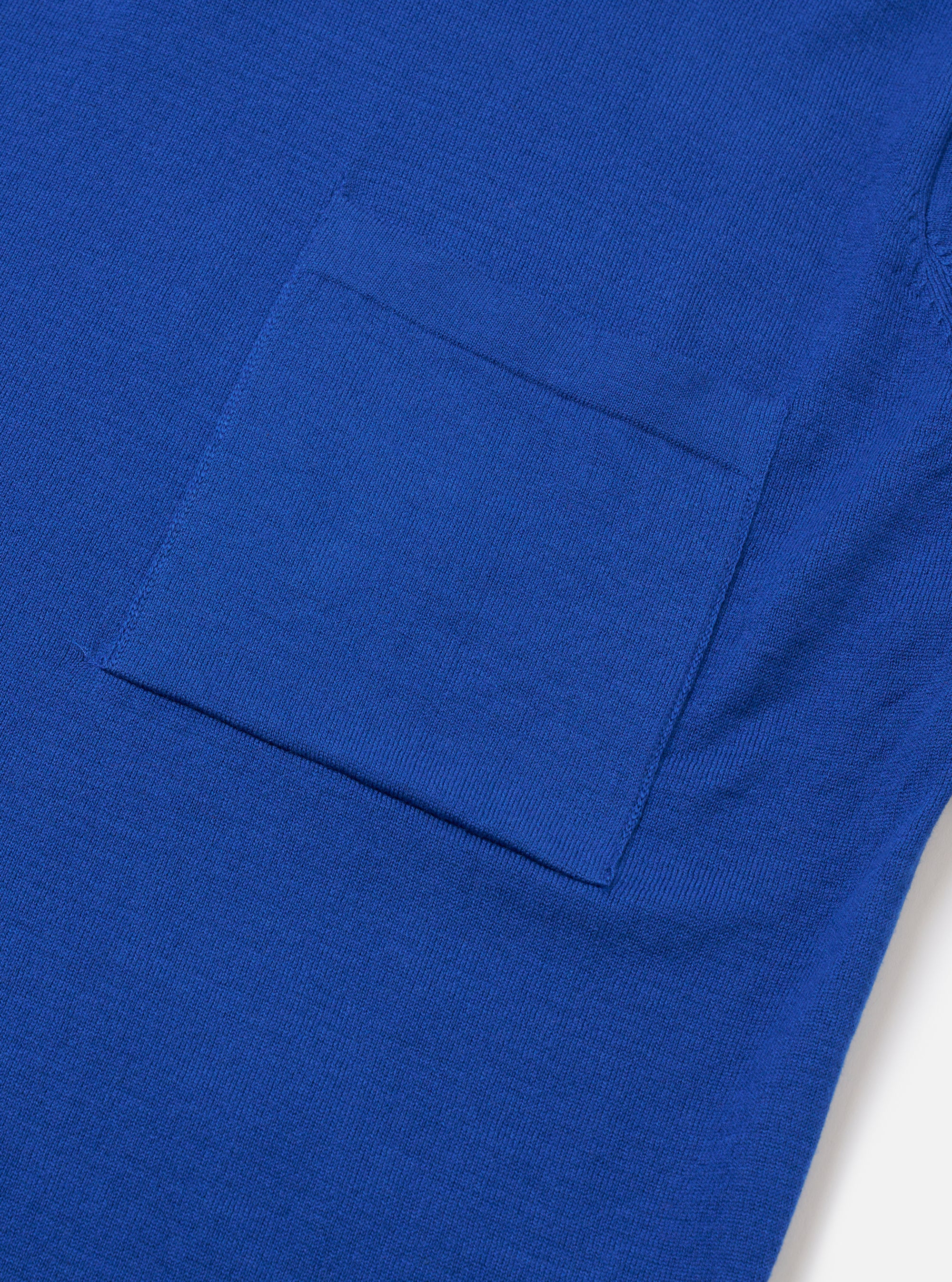 The Blue Woolcot Bio S/S Pullover Knit Shirt II is shown from the back as a flat lay against a plain white background. The image highlights the smooth, lightweight knit texture, short sleeves, and a simple straight hem.