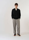 The Black Woolcot Bio Loose Cardigan II is displayed as a flat lay against a plain white background. The cardigan features a V-neckline, a central button-down closure, and two large patch pockets at the waist. The black knit material shows a soft texture with ribbed detailing on the cuffs and hem.