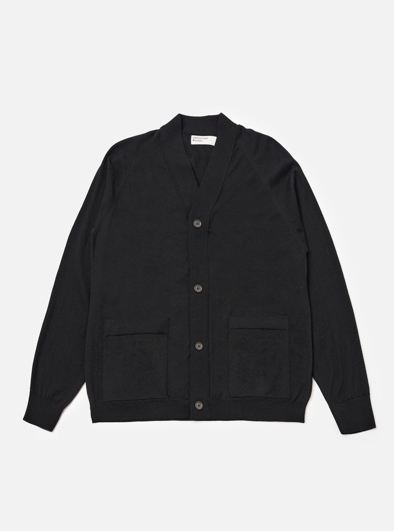 The Black Woolcot Bio Loose Cardigan II is shown as a flat lay against a plain white background. The cardigan features a V-neckline, a wide front button placket, and two patch pockets at the waist. The garment is constructed from a fine-gauge black knit and includes ribbed detailing on the cuffs and hem.