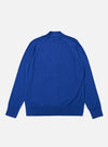 The Blue Woolcot Bio Loose Cardigan II is shown from the back as a flat lay against a plain white background. The image highlights the clean, simple construction of the garment's rear panel, featuring a fine gauge knit and a ribbed hem and cuffs. The dark blue color and relaxed fit are visible.