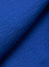 A close-up fabric swatch of the Blue Woolcot Bio Loose Cardigan II highlights the soft, knitted texture and deep blue color of the organic cotton and merino wool blend.
