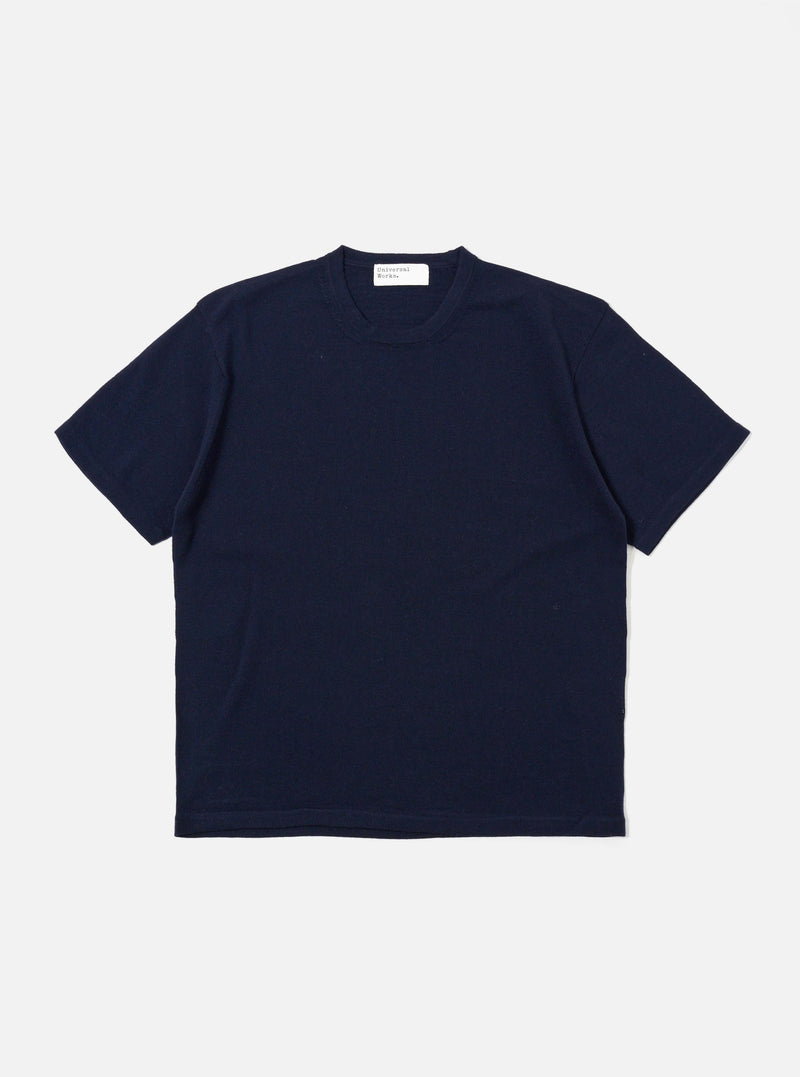 The Navy Merino Fine Knit Knit Tee is displayed as a flat lay against a white background. The short-sleeved garment features a crew neck, ribbed cuffs, and a ribbed hem. The fine merino wool knit provides a smooth, uniform texture throughout.