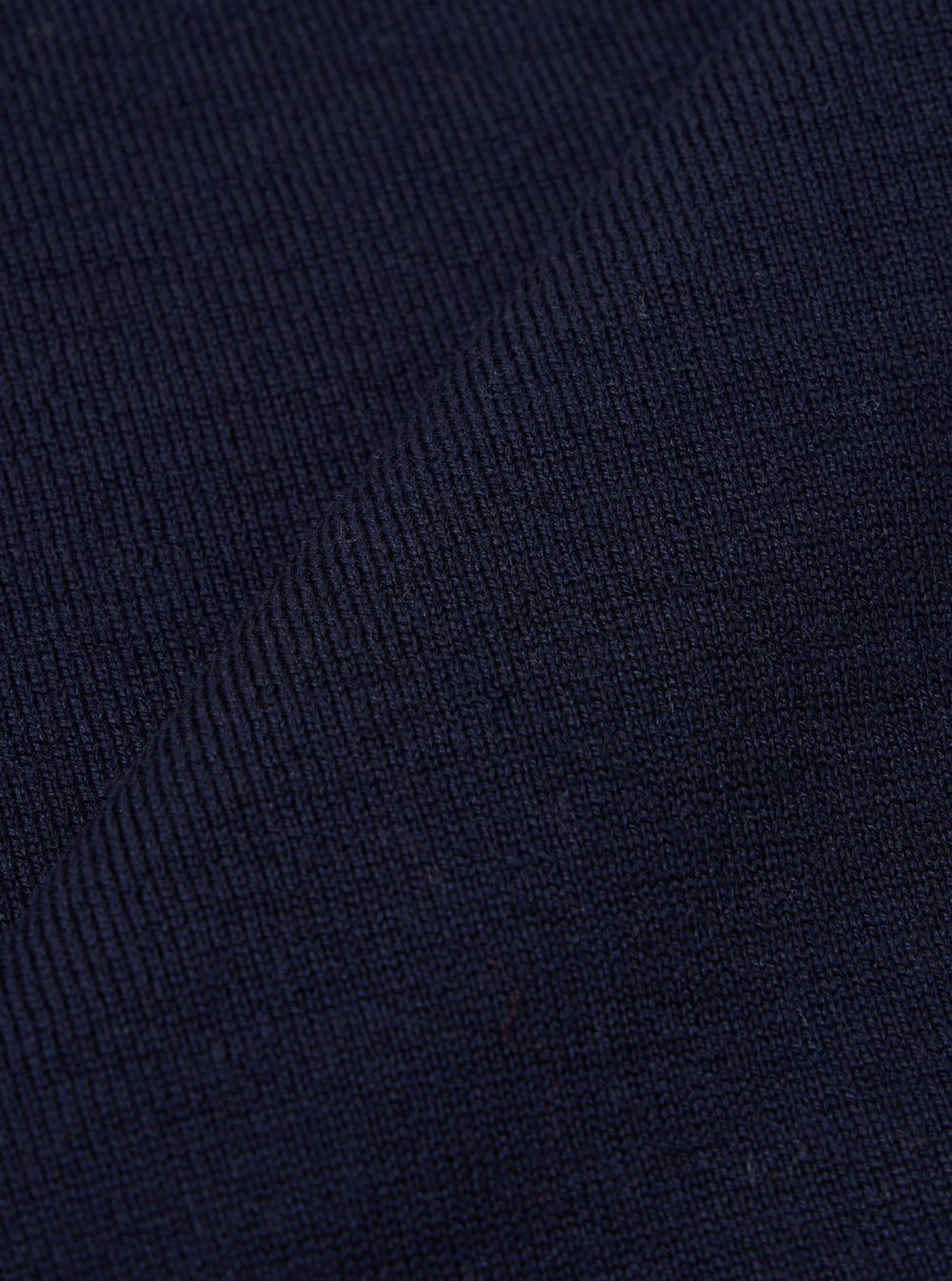 A close-up swatch image of the Navy Merino Fine Knit Knit Tee displays the detailed texture of the dark blue fabric. The fine-gauge knit pattern is the prominent feature of the image. No model or mannequin is present.