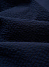 A close-up swatch image of the Navy Derby Stripe Two Button Jacket fabric shows a dark navy blue base with a thin, vertical white stripe pattern. The cotton material is displayed in detail, highlighting the texture and color of the suiting fabric.