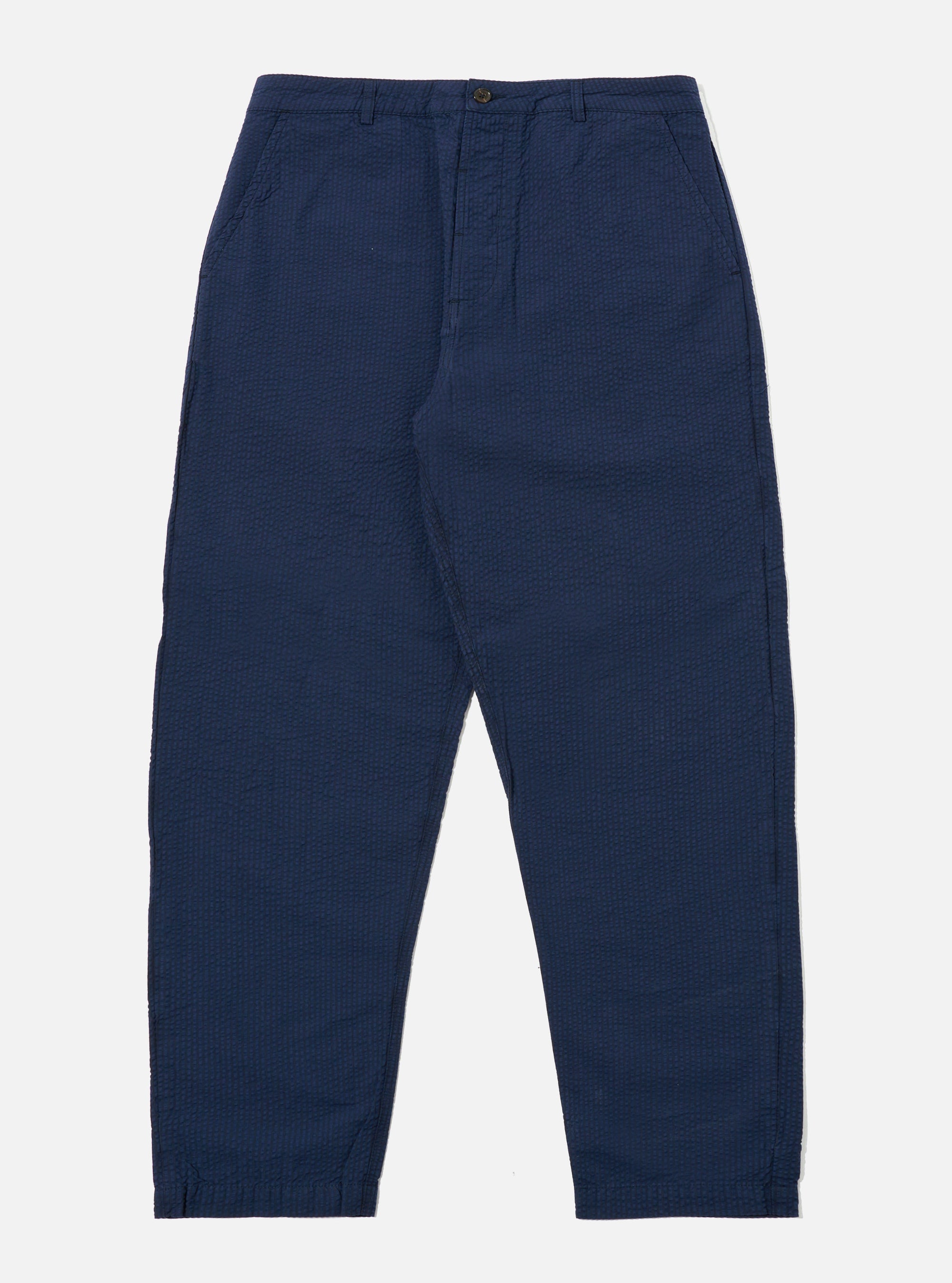 The Navy Derby Stripe Military Chino is presented as a flat lay against a plain white background. The trousers feature a straight-leg cut with a button fly, belt loops, and two slanted front pockets. The fabric is a navy blue cotton with a subtle, vertical derby stripe pattern.