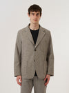 A model wears the Multi Lucas Cotton Mix Two Button Jacket over a light-colored top, standing against a plain white background. The jacket features a relaxed fit with a two-button front closure, a wide lapel, and two large patch pockets at the waist. The fabric has a multi-colored check pattern. No mannequin is present in the image.