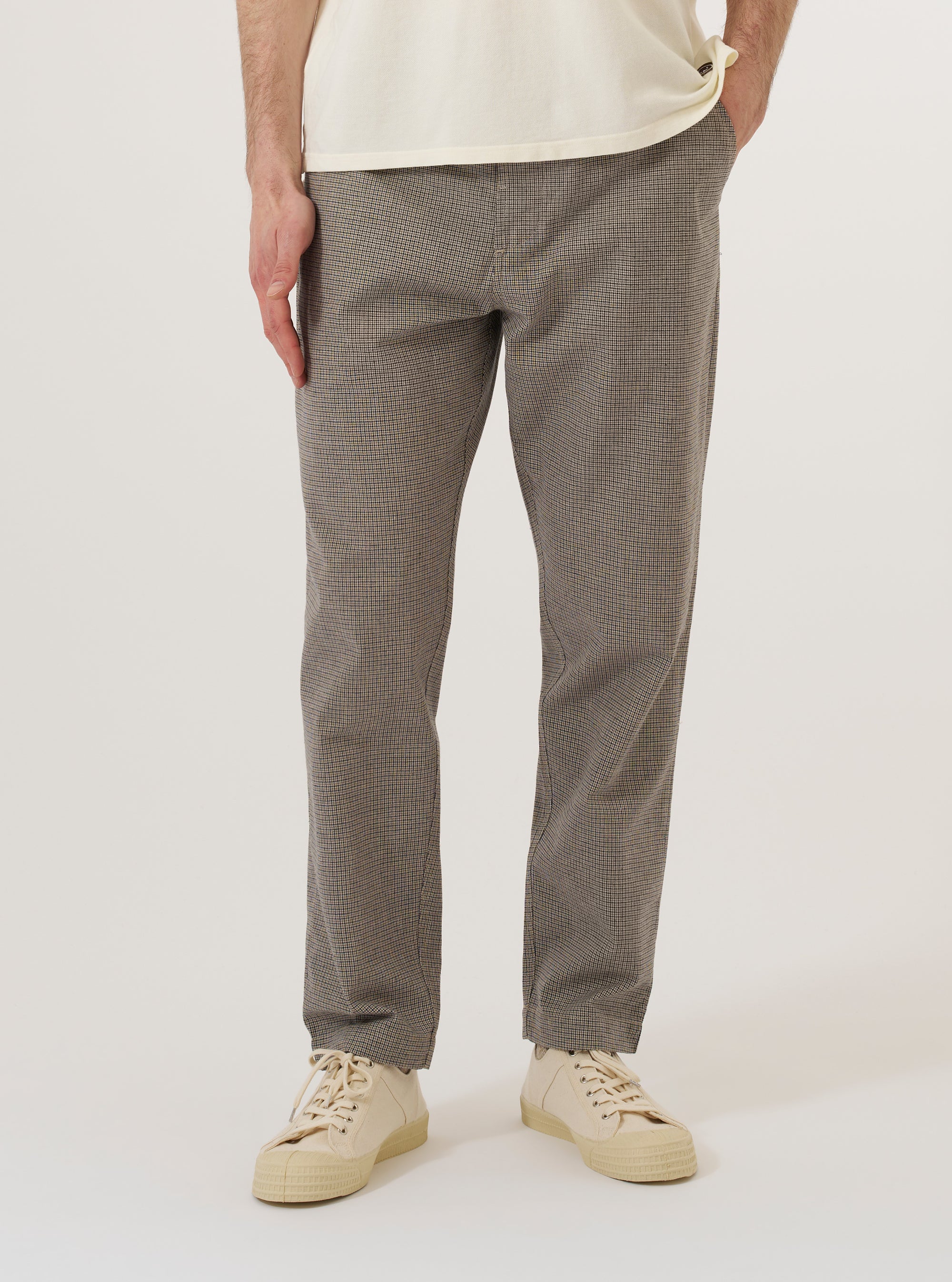 A model wears the Multi Lucas Cotton Mix Military Chino, shown from the waist down against a plain, neutral background. These trousers feature a straight-leg fit and a distinct multi-colored check pattern. The model is standing with one hand in a side pocket, highlighting the garment's functional design and the textured cotton-mix fabric. No mannequin is present in the image.