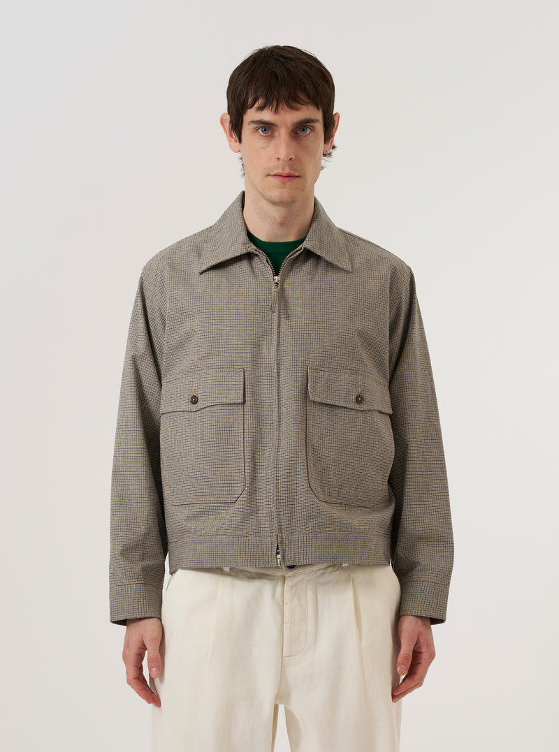 A model wears the Multi Lucas Cotton Mix E130 Jacket over a light-colored shirt, standing against a plain white background. The jacket features an all-over multi-colored check pattern, a classic collar, a central button-down closure, and two large patch pockets at the waist. The textured fabric highlights the cotton, acrylic, and linen blend.