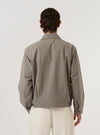 A model wears the Multi Lucas Cotton Mix E130 Jacket, shown from the back against a plain white background. The jacket features an all-over multi-colored check pattern and is crafted from a textured cotton, linen, and acrylic mix. The image highlights the garment's relaxed fit, straight hem, and structured shoulders.
