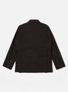 The Licorice Summer Canvas Manor Jacket is shown from the back as a flat lay against a plain white background. The image highlights the jacket's simple back construction, featuring a central vertical seam and a straight hem. The dark brown canvas fabric has a visible, textured finish.