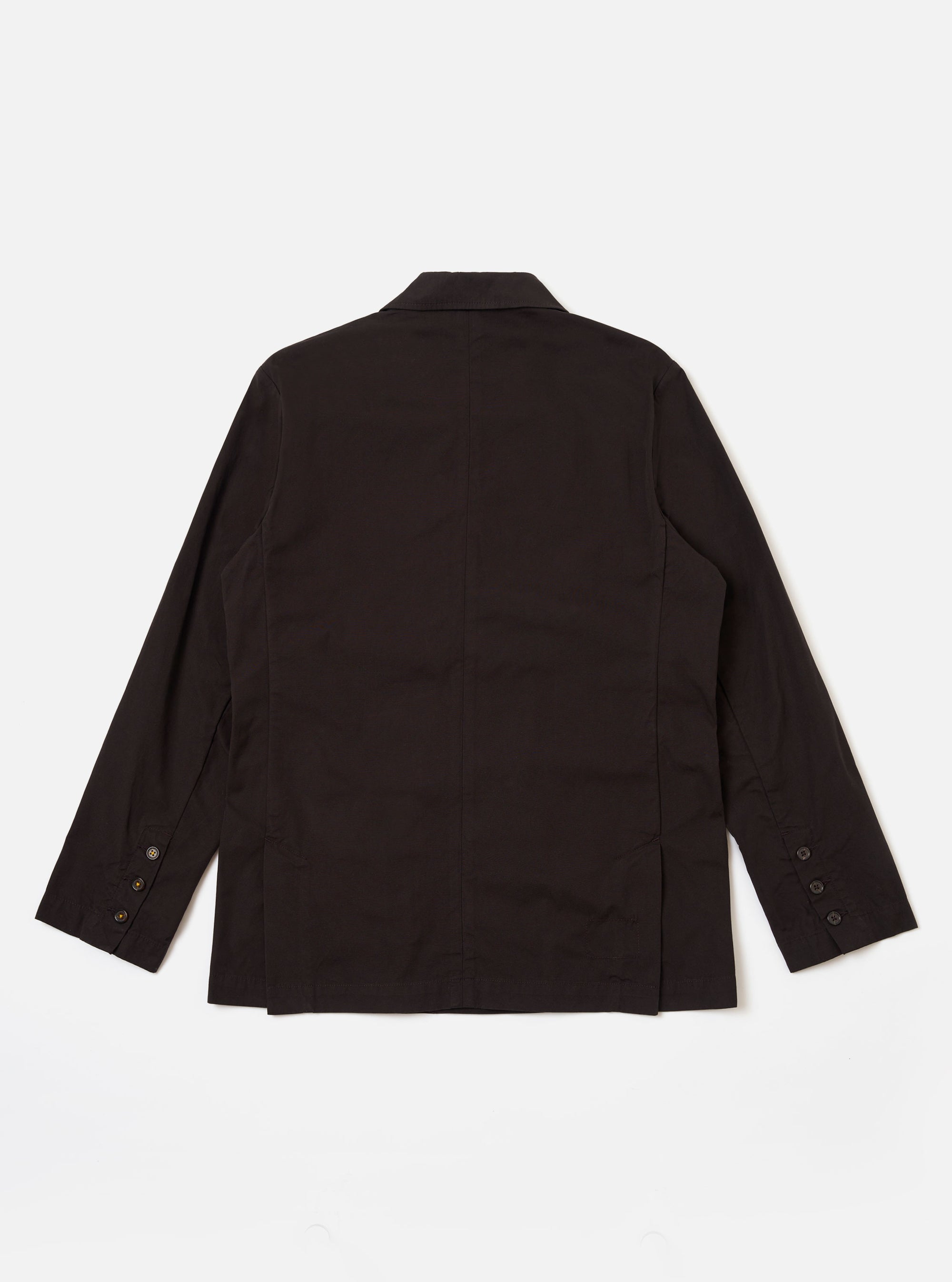 The Licorice Summer Canvas Manor Jacket is shown from the back as a flat lay against a plain white background. The image highlights the jacket's simple back construction, featuring a central vertical seam and a straight hem. The dark brown canvas fabric has a visible, textured finish.