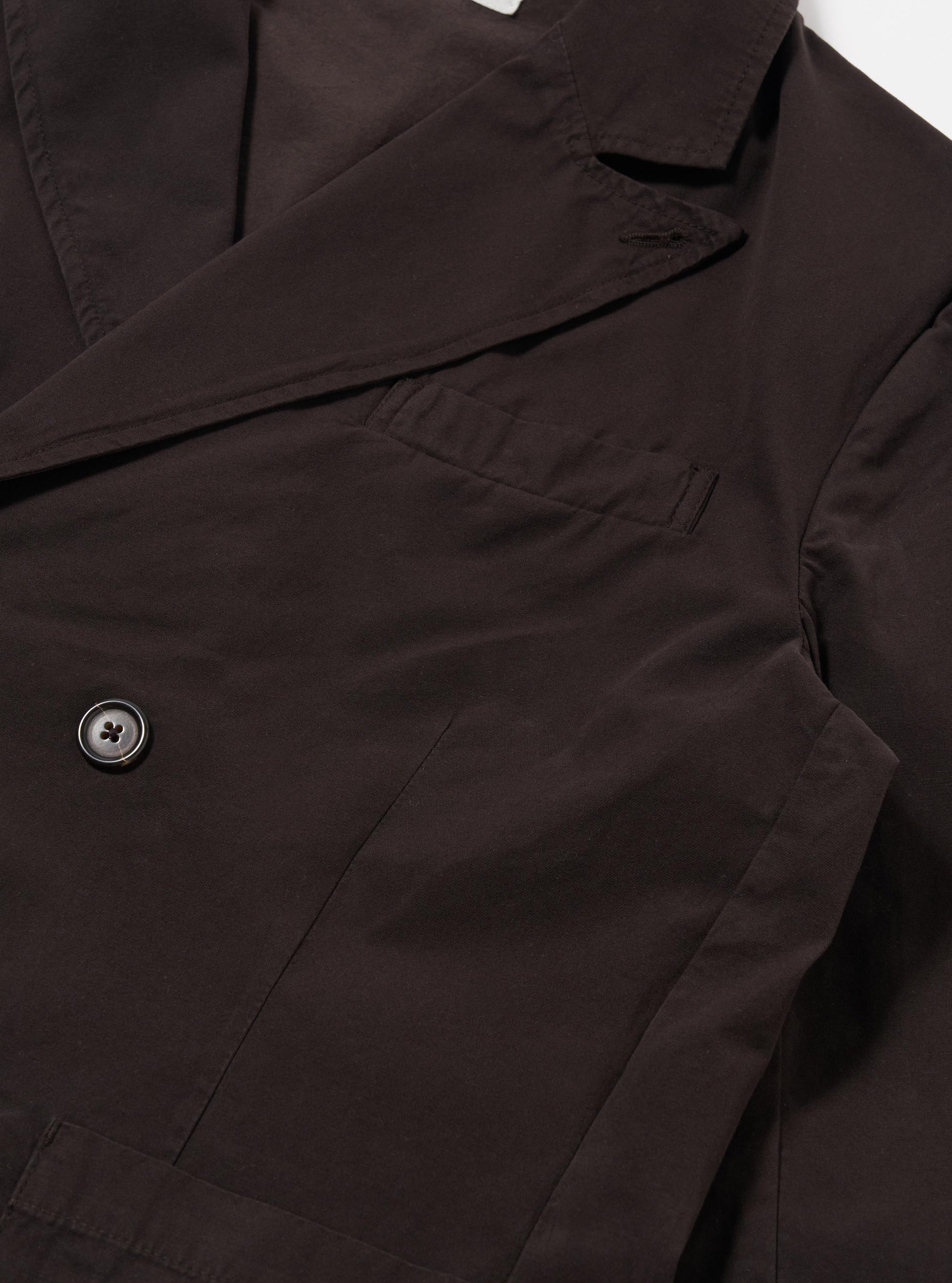 The Licorice Summer Canvas Manor Jacket is shown from the back as a flat lay against a white background. The jacket features a clean back panel with double vents at the hem and a structured, two-piece sleeve design. The licorice-colored cotton canvas fabric has a visible textured appearance.