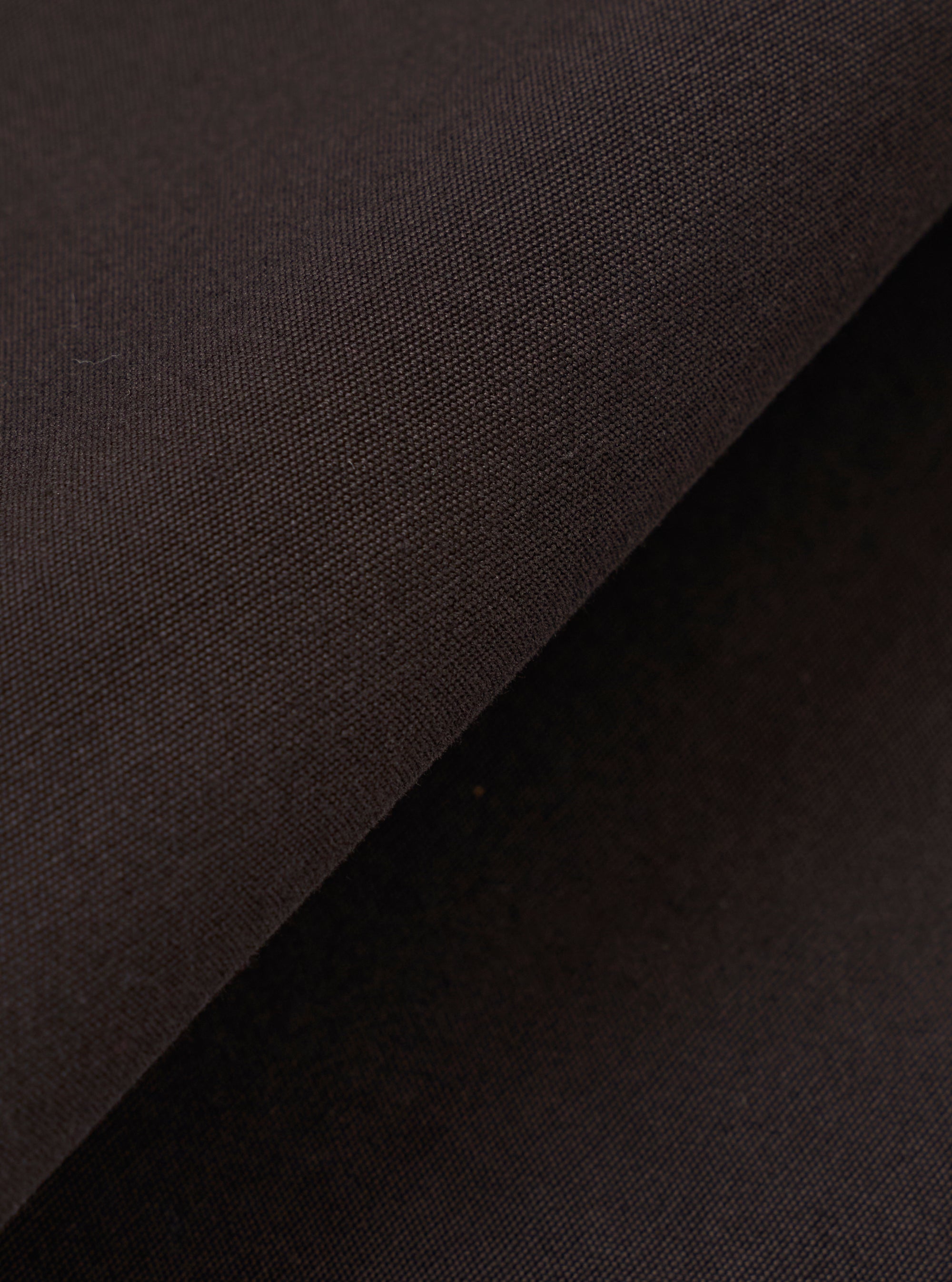 A close-up swatch image of the Licorice Summer Canvas Clean Short fabric. The image focuses on the dark brown cotton canvas material, highlighting its durable, tight-weave texture and consistent color. The fabric fills the frame, and no model or mannequin is present.