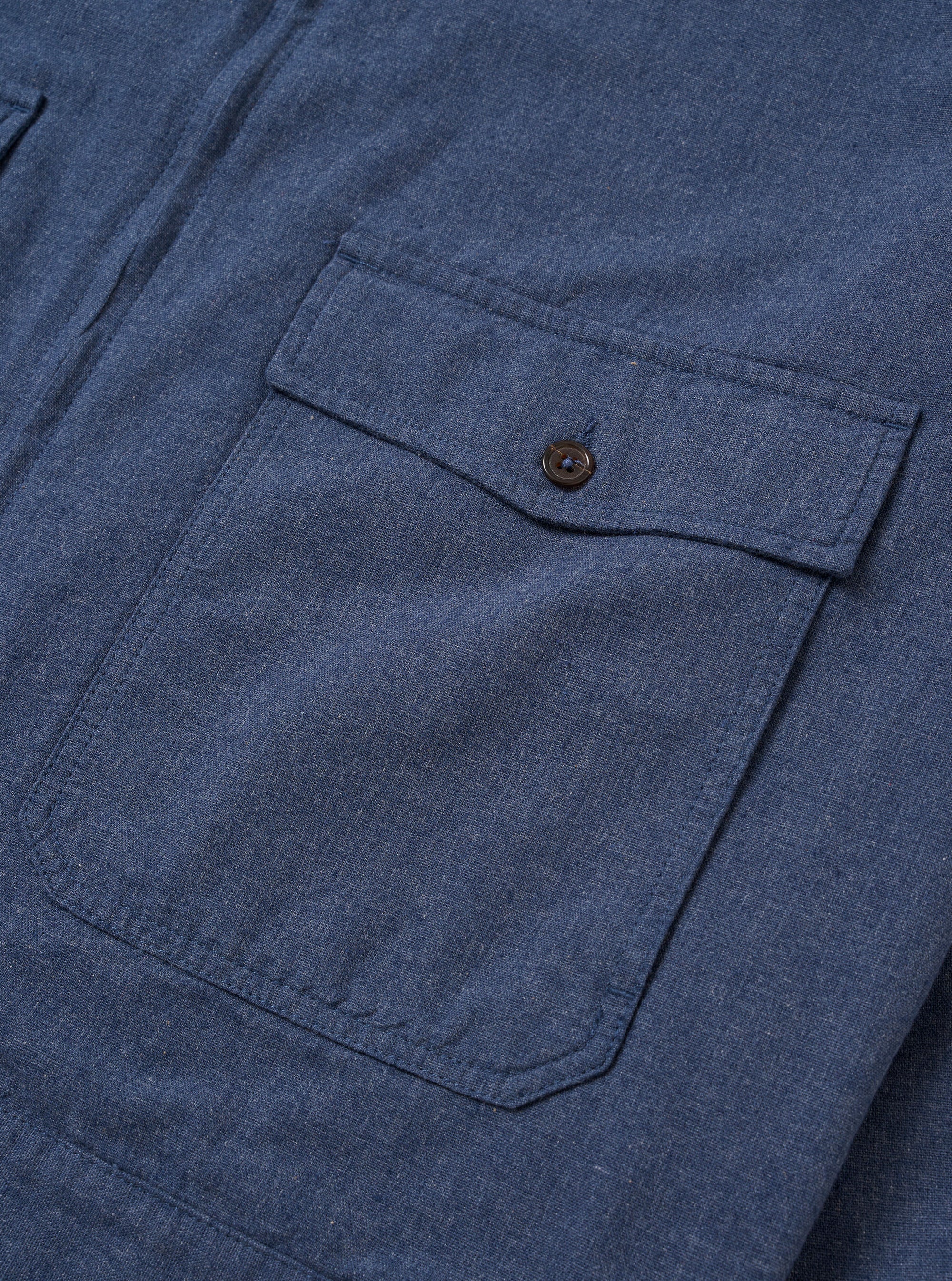 The Blue Sintra Recycled Cotton E130 Jacket is shown from the back as a flat lay against a plain white background. The image highlights the clean, simple construction of the garment's rear, featuring a straight hem and a standard pointed collar. The recycled cotton fabric is a solid, mid-blue color with a smooth texture.
