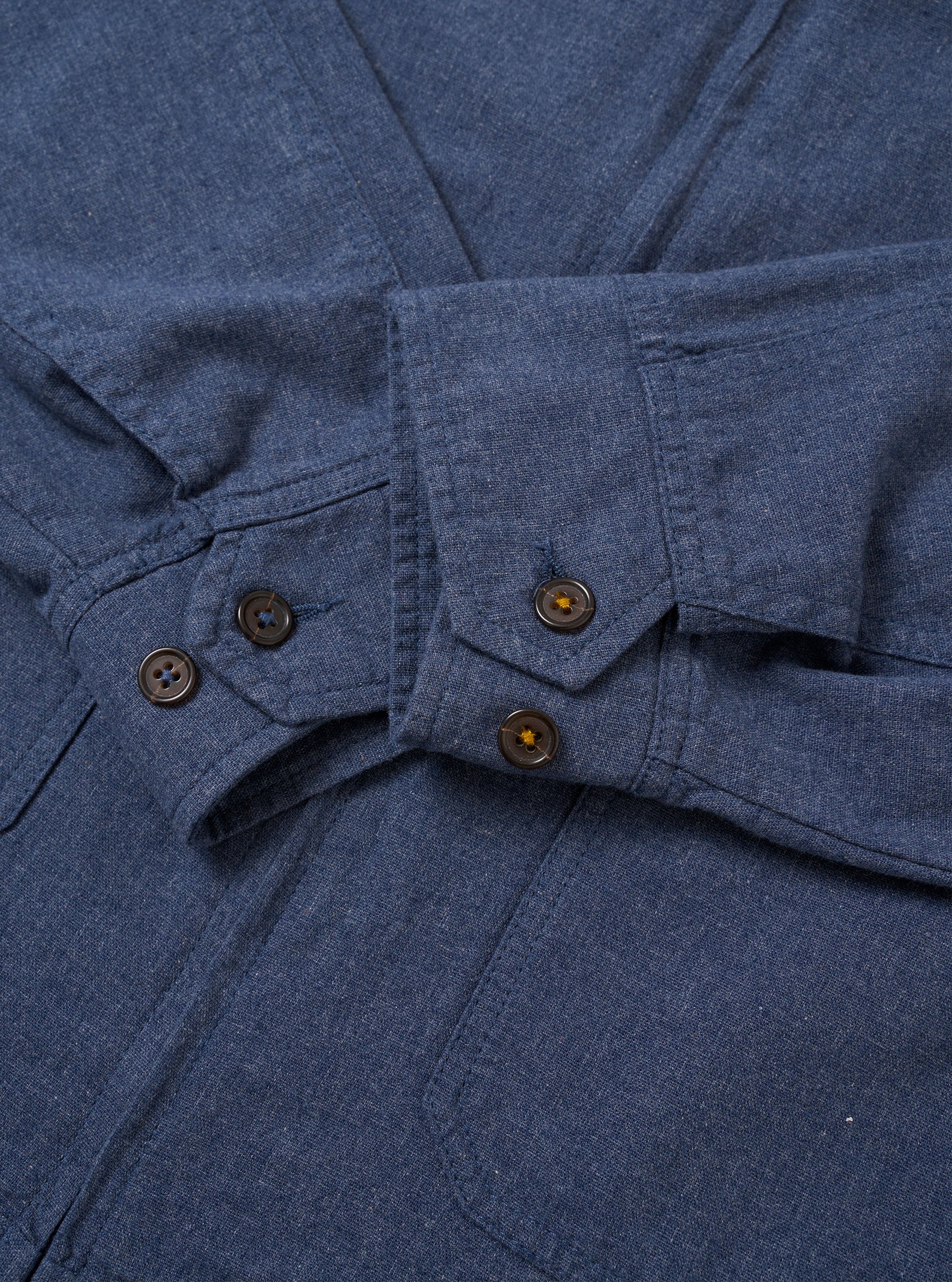 The Blue Sintra Recycled Cotton E130 Jacket is shown from the back as a flat lay against a plain white background. The image highlights the clean, simple construction of the garment's rear, the straight hem, and the smooth blue recycled cotton fabric.