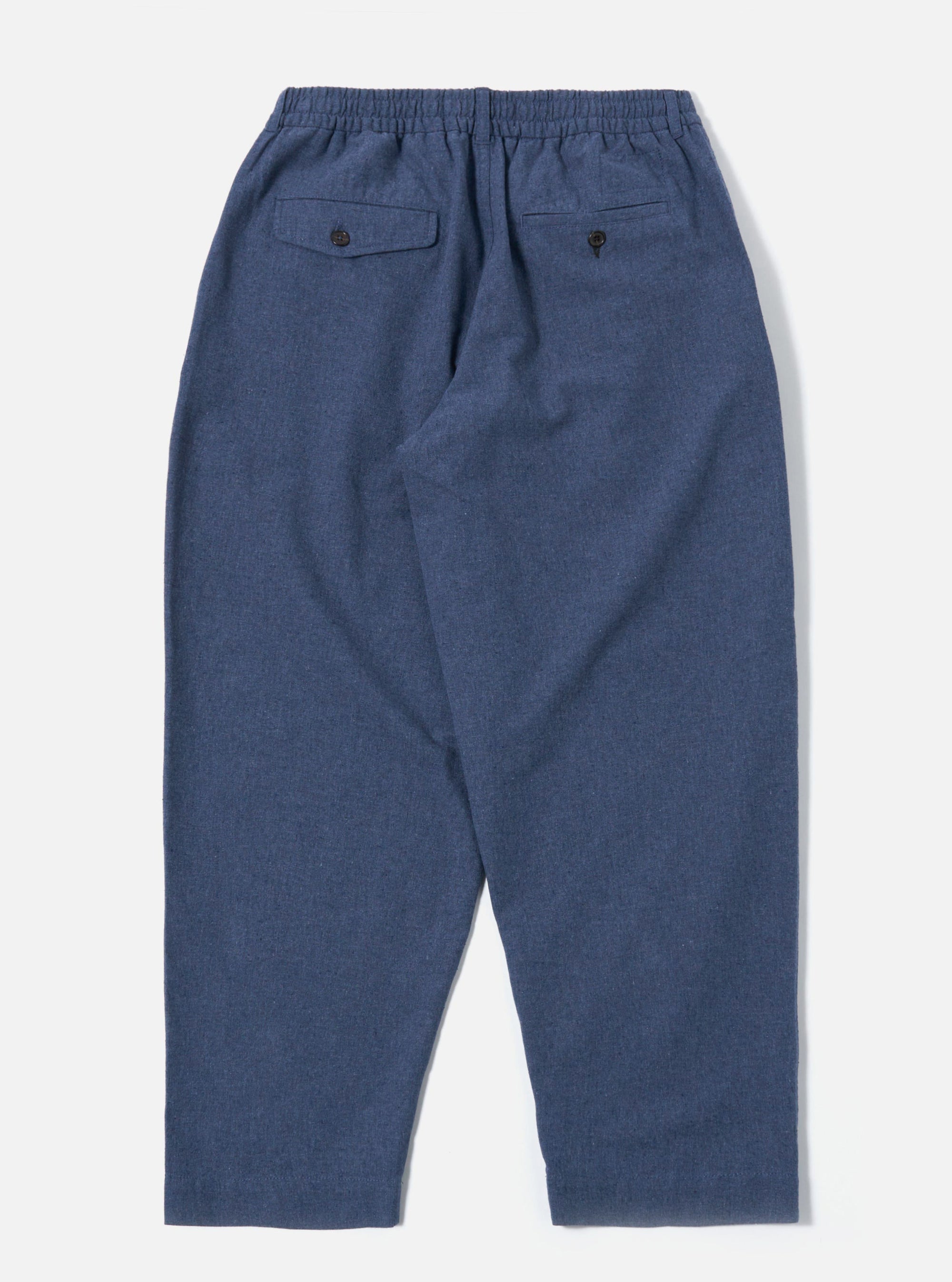 The Blue Sintra Recycled Cotton Oxford Pant is shown from the back as a flat lay against a plain white background. The image highlights the two rear patch pockets and the elasticated drawstring waistband. The trousers are a solid blue color and appear to have a wide, relaxed fit.