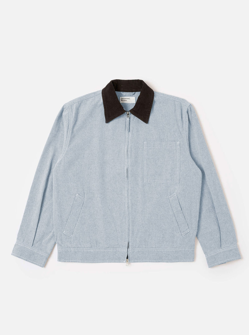 The Light Indigo Jean Cloth Reworked Rose Bowl Jacket is shown as a flat lay against a white background. The jacket features a double-ended zip front, a structured collar, one large chest patch pocket, and two side welt pockets. The light indigo fabric is made from a reworked organic cotton blend with a visible denim-like texture.