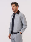 A model wears the Light Indigo Jean Cloth Reworked Rose Bowl Jacket against a plain white background. The jacket features a boxy fit, a structured collar, and a zip-front closure. One large patch pocket is visible on the chest, along with two welt pockets at the waist. The light indigo fabric is made from a reworked denim cloth with visible panelled construction and stitching details. The model is standing and facing the camera with the jacket zipped up.