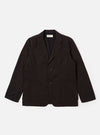 The Licorice Summer Canvas Two Button Jacket is presented as a flat lay against a solid white background. The jacket features a notched lapel, two-button front closure, a single chest patch pocket, and two large patch pockets at the waist. The cotton canvas fabric has a rich brown color and a subtle, textured appearance.