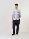 The Soft Blue Mc Stripe Road Trip Shirt is shown as a flat lay against a white background. The shirt features a camp collar, a full-length button-down front, and a straight hem. The fabric is a soft blue with a horizontal stripe pattern.