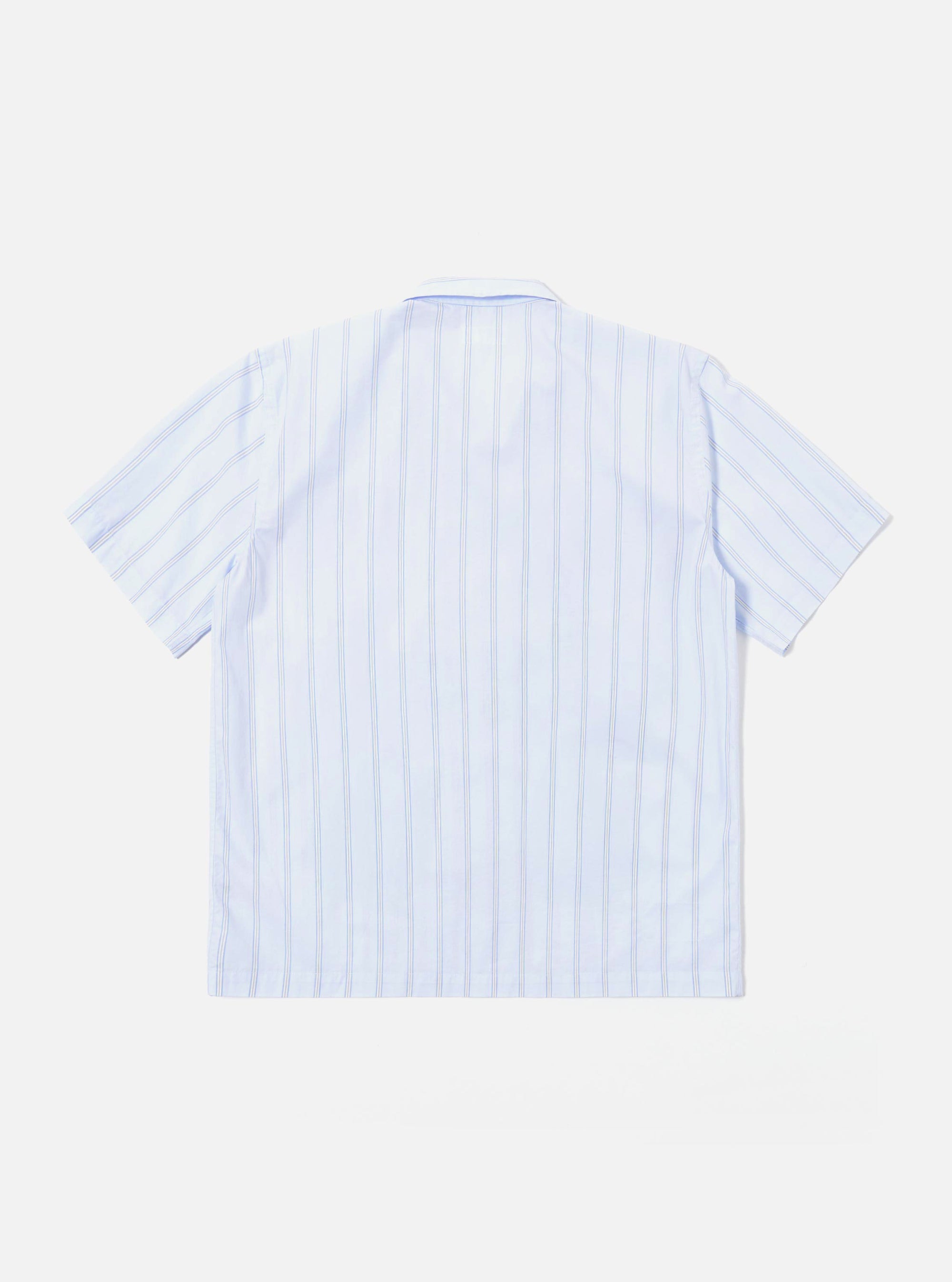 The Soft Blue Mc Stripe Road Trip Shirt is shown as a flat lay against a white background. The shirt features a camp collar, a full-length button-down front, and a straight hem. The fabric has a light blue and white striped pattern with intricate tropical foliage embroidery on the right side of the chest.