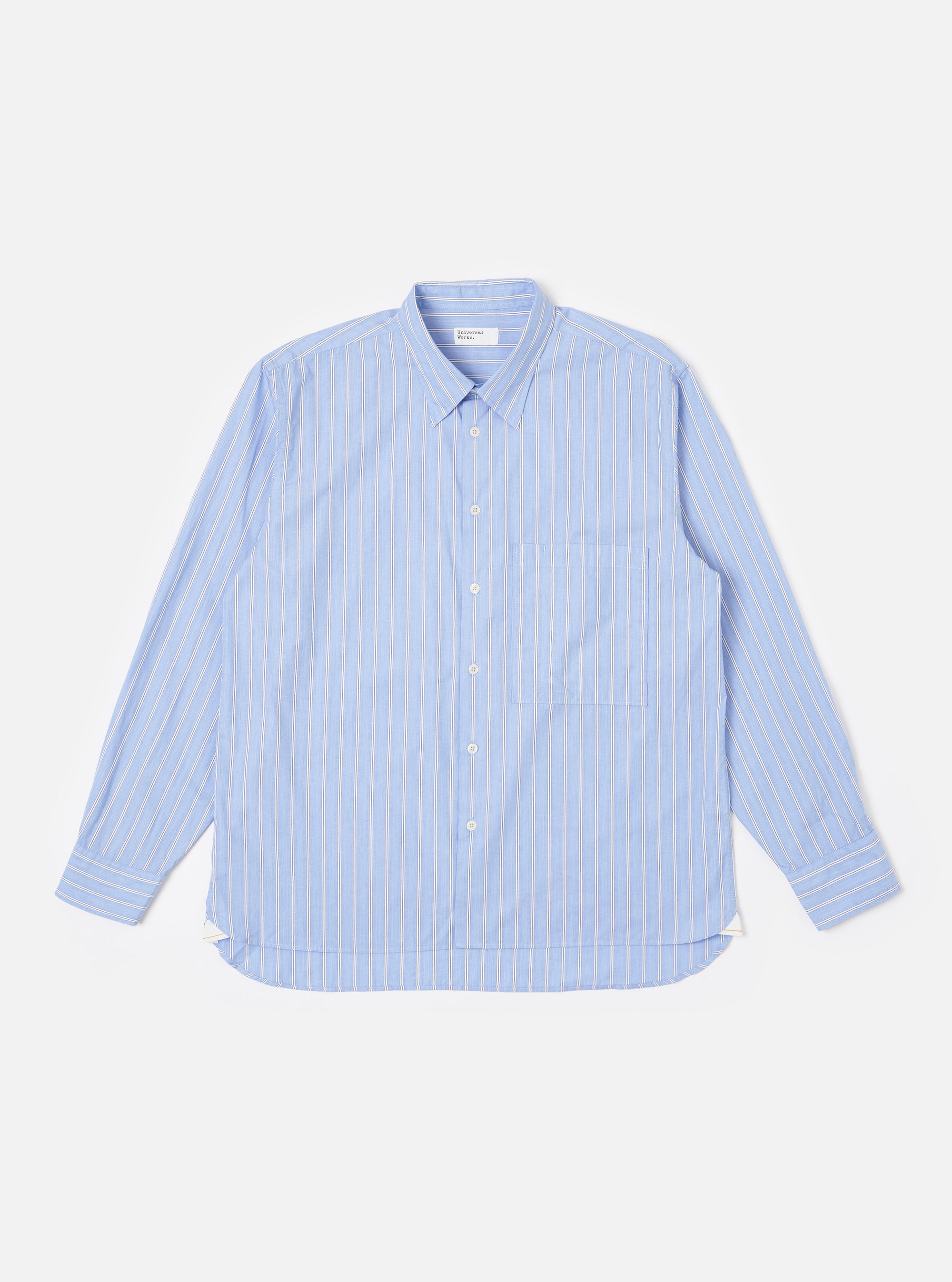 The Blue Mc Stripe Square Pocket Shirt is shown as a flat lay against a plain white background. The shirt features a blue and white pinstripe pattern, a full button-down front, a point collar, and a large, oversized square patch pocket on the left chest. The long sleeves are finished with button cuffs, and the garment has a curved hem.