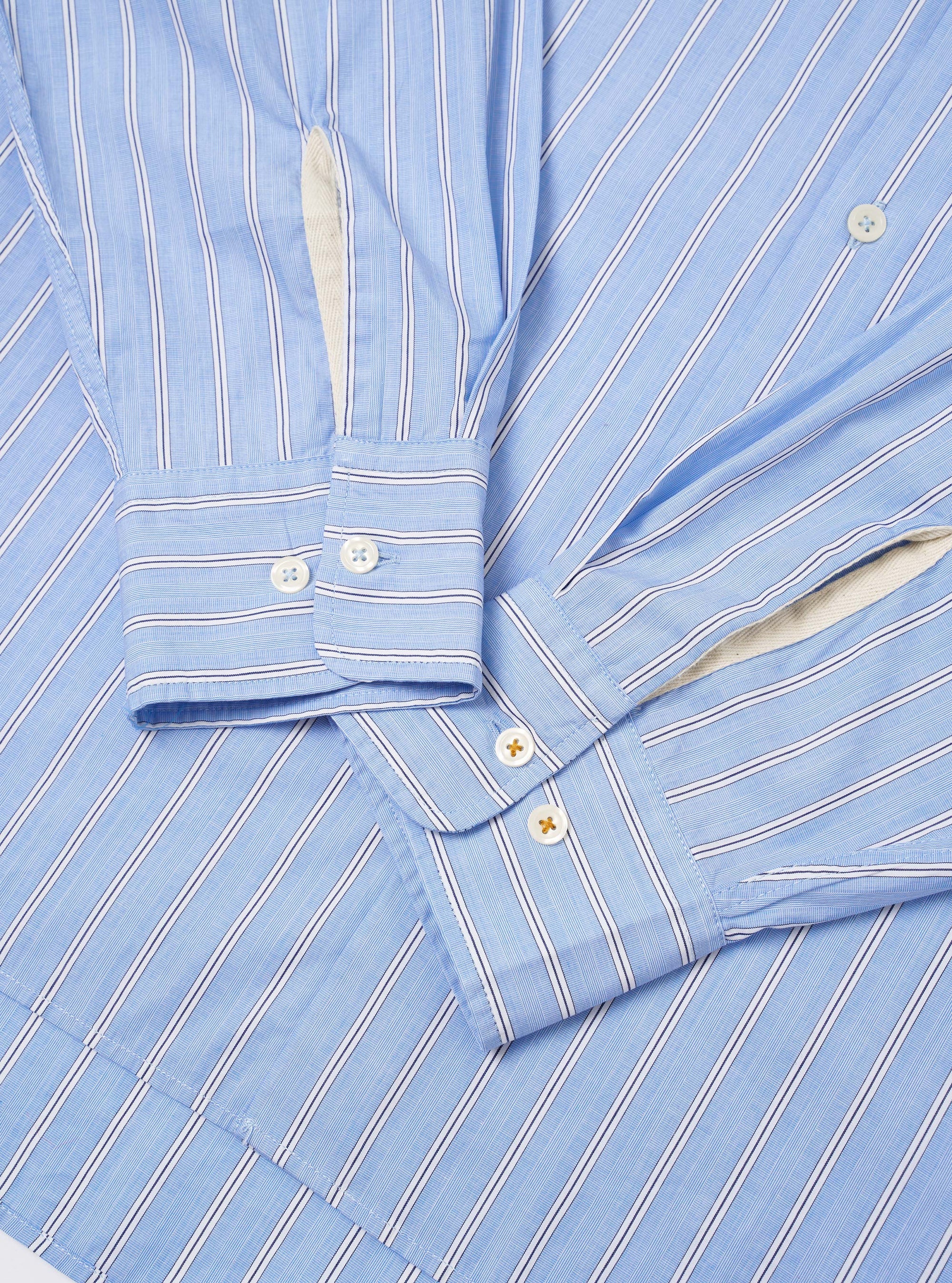 The Blue Mc Stripe Square Pocket Shirt is shown from the back as a flat lay against a plain white background. The image highlights the shirt's vertical blue and white stripes, the back yoke, and a curved hem.