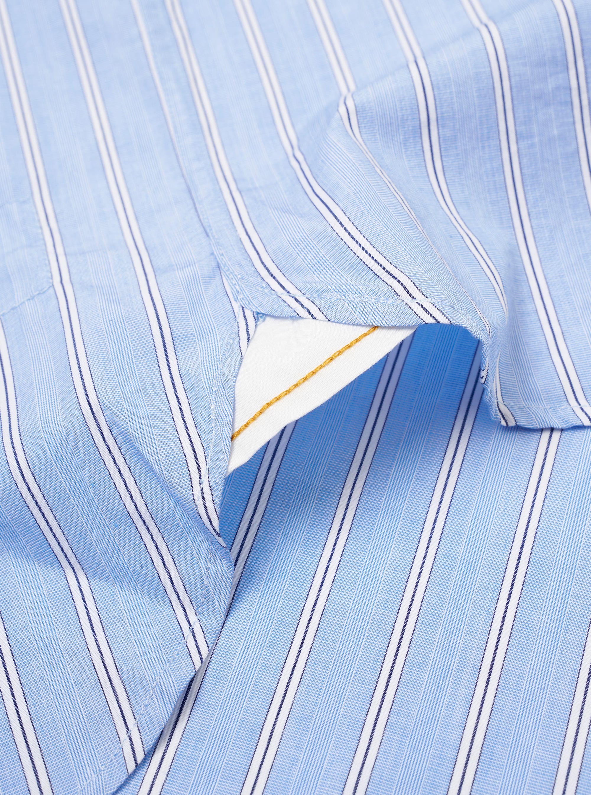 The Blue Mc Stripe Square Pocket Shirt is shown from the back as a flat lay against a plain white background. The image highlights the clean construction of the shirt, featuring a structured back yoke and a curved hem. The blue and white vertical stripe pattern is visible across the cotton fabric.