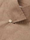 A model is wearing the Brown Sido Linen Mix Road Shirt, shown from the chest down against a plain white background. The shirt is unbuttoned over a white t-shirt, highlighting the camp collar, a single chest patch pocket, and a straight hem. The fabric has a textured linen-cotton weave and a subtle tonal pattern.