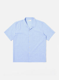 The Sky Blue Sido Linen Mix Road Shirt is shown as a flat lay against a plain white background. The shirt features a camp collar, a central button-down front with tonal buttons, and a single patch pocket on the left chest. The fabric is a lightweight sky blue cotton-linen blend with a subtle texture.