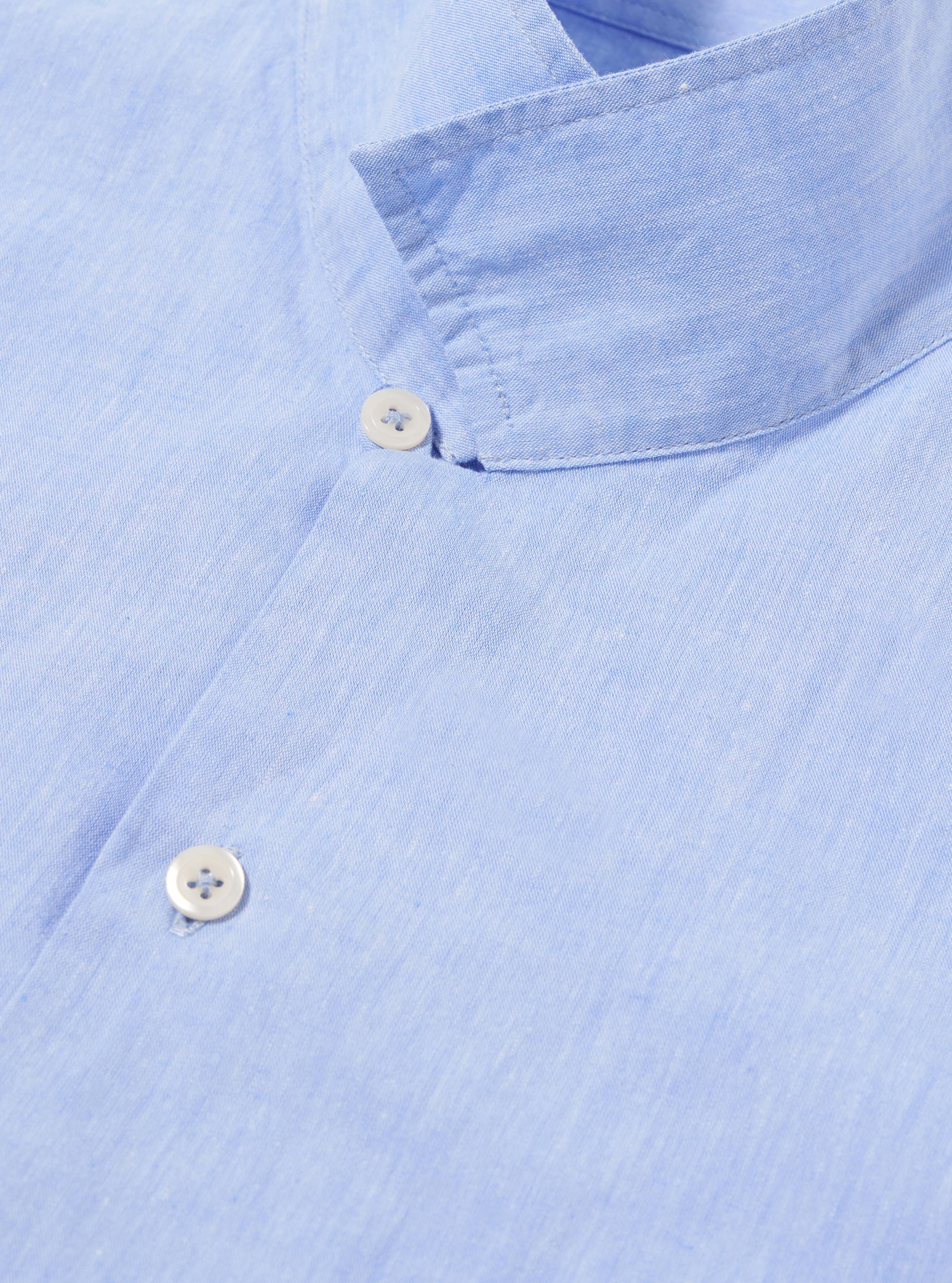 The Sky Blue Sido Linen Mix Road Shirt is shown from a rear three-quarter angle as a flat lay against a plain white background. The image highlights the straight hem, short sleeves, and the lightweight, textured linen-blend fabric in a pale sky blue.