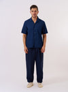 The Indigo Lincot Denim Road Shirt is shown as a flat lay against a white background. The shirt features a camp collar, a single chest patch pocket on the left side, and a full button-down front with light-colored buttons. The fabric is a dark indigo denim with visible stitching details.