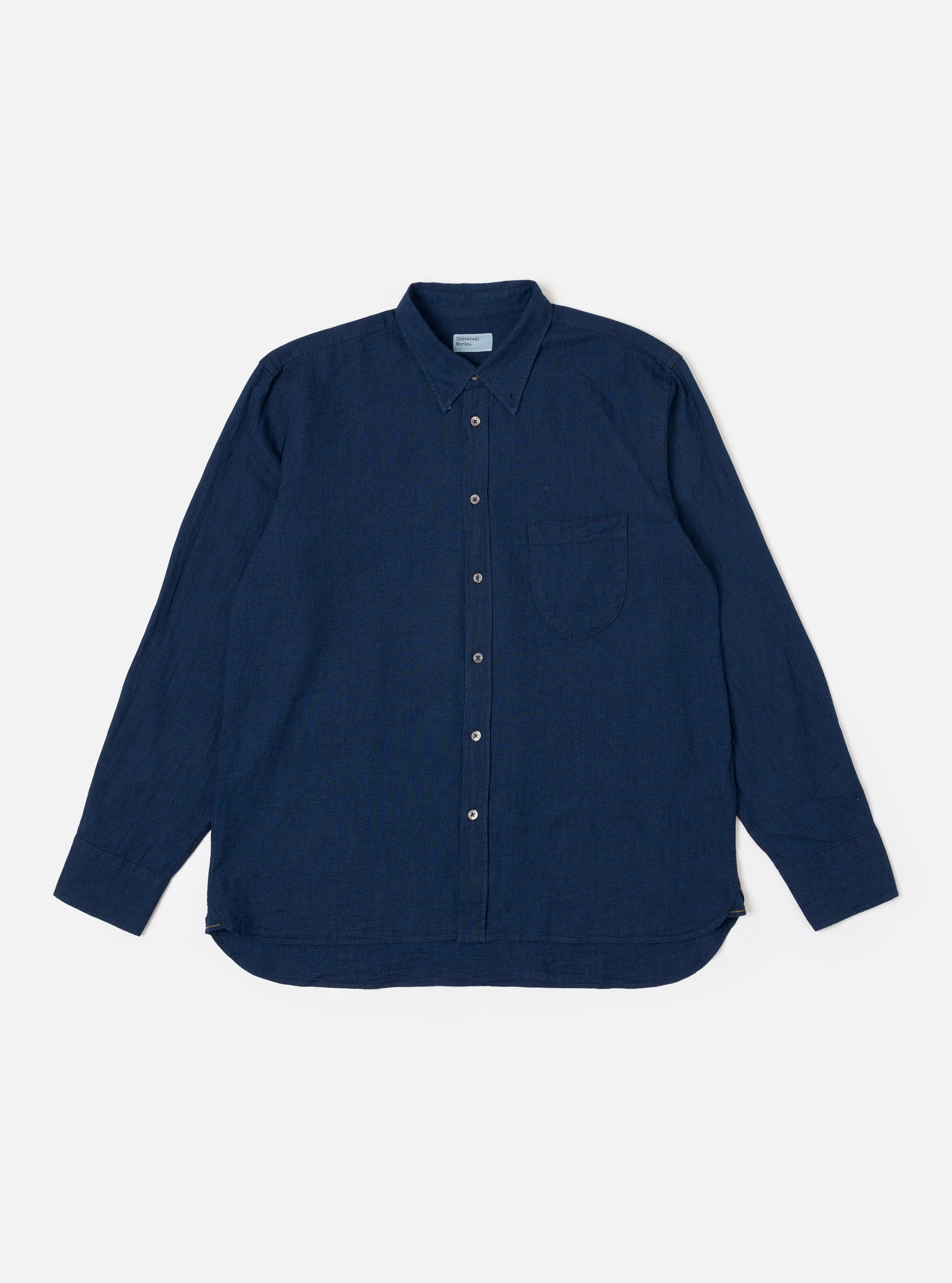 The Indigo Lincot Denim Lazy Day Shirt is shown as a flat lay against a white background. The shirt features a button-down collar, a central button closure, and a single asymmetrical chest pocket on the left side. The indigo blue fabric is a blend of cotton and linen with a visible denim texture.