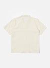 The Ecru Arten Seersucker Road Shirt is shown from the back as a flat lay against a plain white background. The image highlights the shirt's straight hem, short sleeves, and the distinct puckered texture of the ecru seersucker fabric. A clean horizontal yoke is visible across the shoulders.