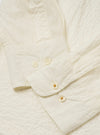 The Ecru Arten Seersucker Attendant Shirt is shown from the back in a flat lay against a plain white background. The image highlights the shirt's straight hem, simple back panel, and the puckered texture of the ecru seersucker fabric.