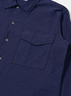 The Navy Arten Seersucker Attendant Shirt is shown from a rear angle as a flat lay against a plain white background. The image highlights the shirt's textured seersucker fabric, a straight hem, and a simple back yoke with a central box pleat.