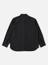 The Black Tropical Suiting Travail Overshirt is shown from the back as a flat lay against a plain white background. The image highlights the clean, simple construction of the garment's rear and the smooth texture of the black wool-blend tropical suiting fabric.