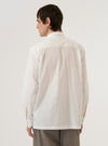 A model wears the Ecru Organic Fine Poplin CPO Shirt, shown from a rear three-quarter angle against a plain white background. The shirt features a clean back construction, a classic pointed collar, and a straight hem. The smooth, off-white ecru fabric of the organic fine poplin is clearly visible as the model stands facing away from the camera.