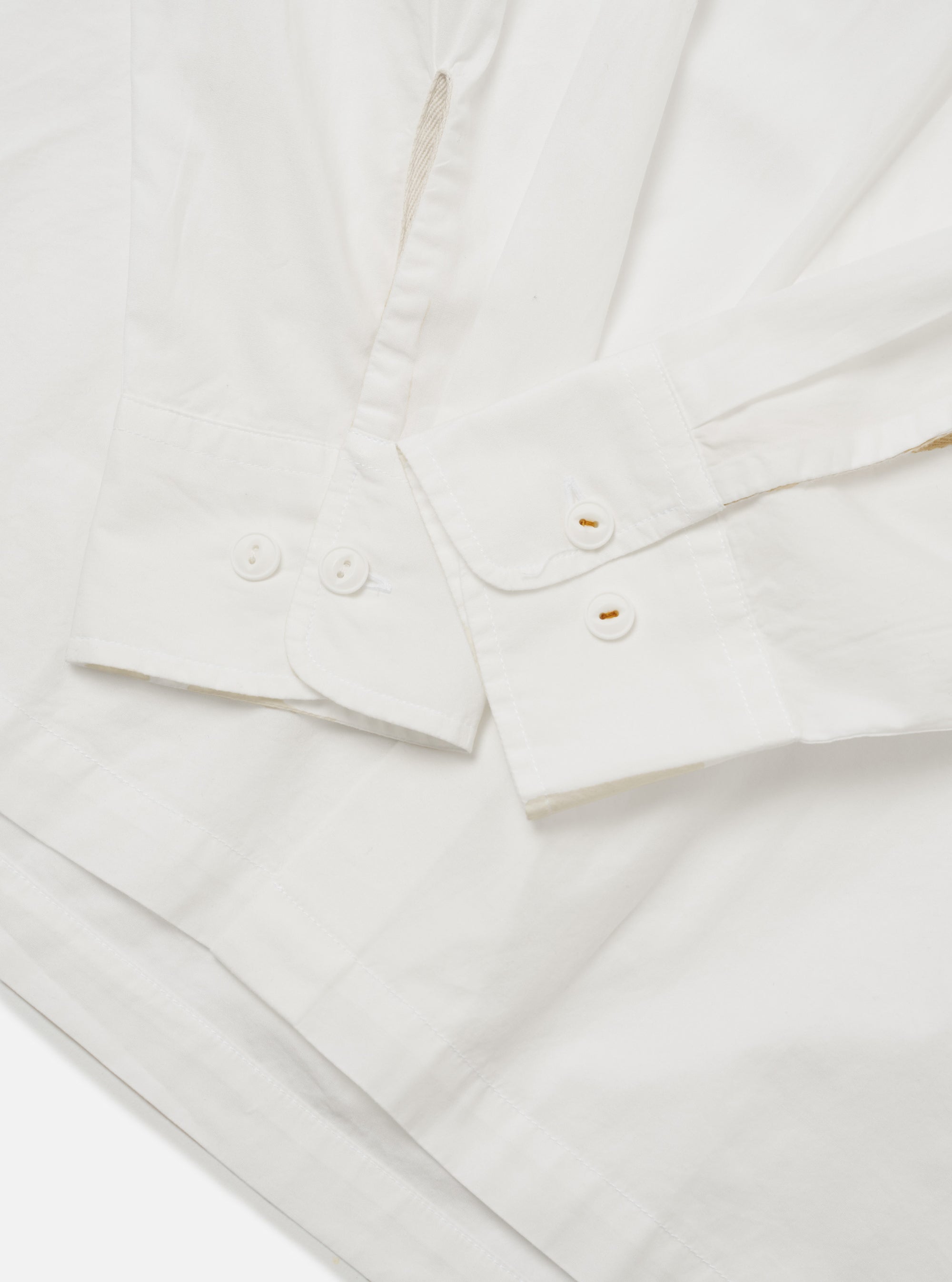 The Ecru Organic Fine Poplin CPO Shirt is shown from the back as a flat lay against a plain white background. The image highlights the garment's relaxed loose fit, straight hem, and the clean construction of the two-piece collar and rear yoke. The fabric is a solid ecru organic cotton poplin with a smooth, lightweight finish.